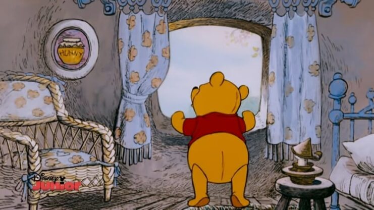 Winnie The Pooh is in the house looking out the window